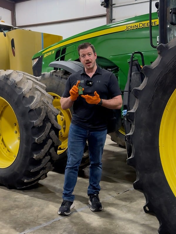 Tim MacDonald filming UGC content beside a John Deere tractor